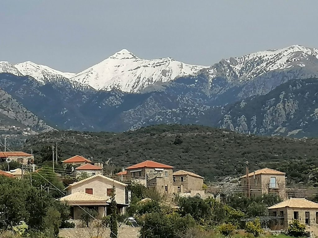 Traditional Mani village beneath the snow-covered peaks of Mount Taygetos