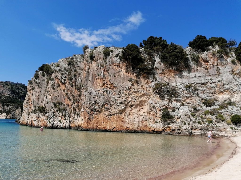 Impressive rocky cliff at the edge of Voidokilia Beach, beside the shallow waters