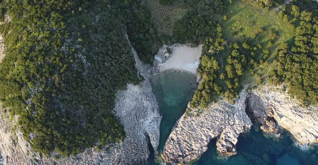 Glossa Beach enclosed by rocky cliffs